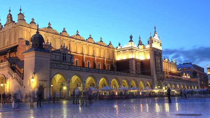 The majestic Cloth Hall (Sukiennice) in Kraków’s Main Market Square, with a clear blue sky in the background.