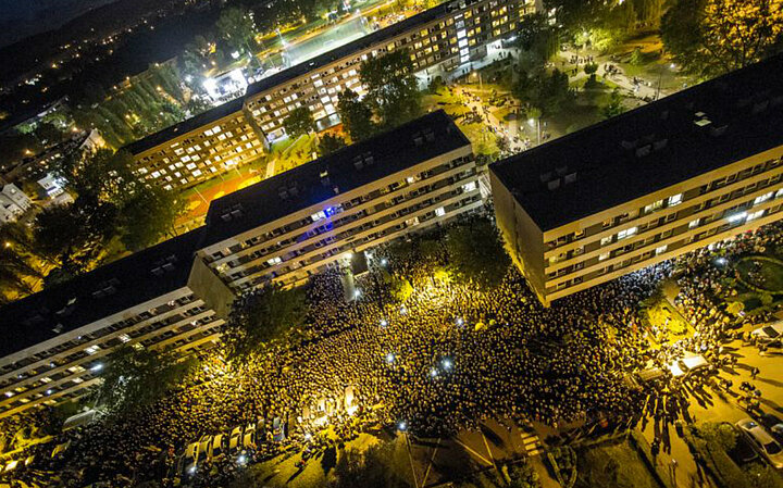 AGH campus in the evening, with a large crowd at an outdoor concert and a festive display of lights.